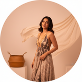 Circular portrait of Meera Joshi, an Indian woman, smiling in the Aureyra Maxi Dress. The background is clean and softly lit 