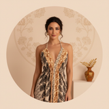 Circular portrait of Clara Dubois, a well-traveled woman, smiling and wearing the Aureyra Maxi Dress with a deep V-neckline. 